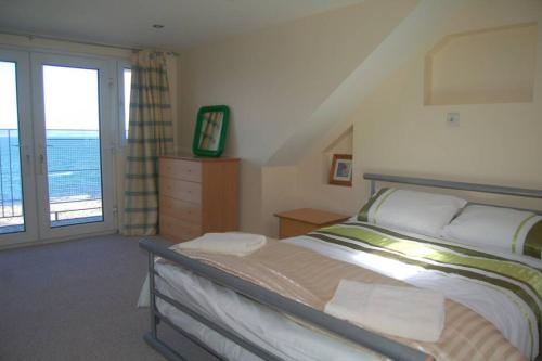a bedroom with a bed with a view of the ocean at Splash Cottage, Bangor, Co Down in Bangor