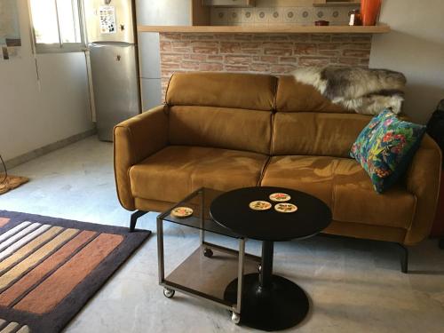 un salon avec un canapé marron et une table dans l'établissement Studio standing Nice, à Nice