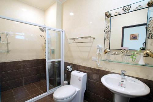 a bathroom with a toilet and a sink and a shower at Taitung Matsunogien in Taitung City