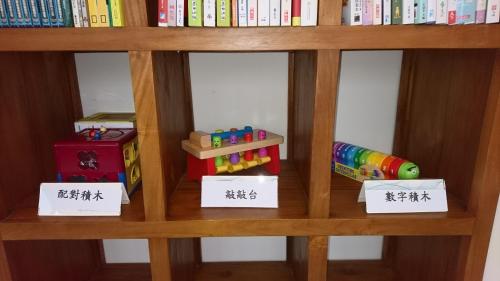 a book shelf with books and toys on it at Taitung Matsunogien in Taitung City