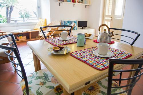 a wooden table with a tea kettle on top of it at Casa Delta delle Acque Vista spettacolare e Giardino in Cala Gonone