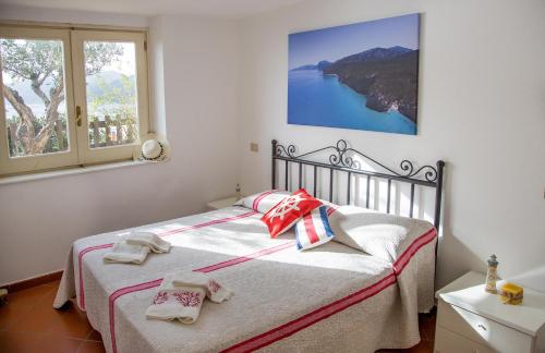 a bedroom with a bed with towels on it at Casa Delta delle Acque Vista spettacolare e Giardino in Cala Gonone