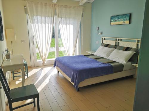 Schlafzimmer mit einem Bett, einem Schreibtisch und einem Fenster in der Unterkunft Tenuta San Marcello in San Marcello