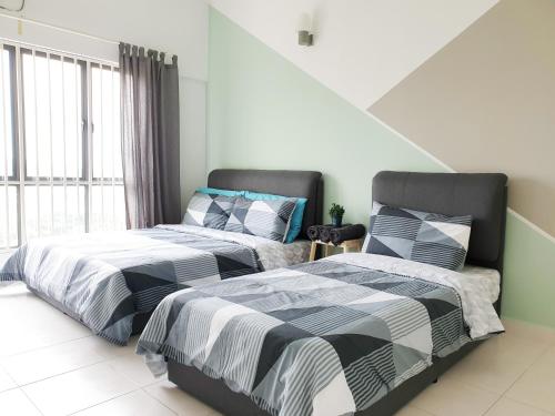 two beds sitting next to each other in a bedroom at Family Apartment at Setia Walk Puchong near IOI Mall Puchong LRT Station in Puchong