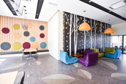 a room with colorful chairs and a wall with planets at Kisetsu no ie, KLCC Kuala Lumpur in Kuala Lumpur