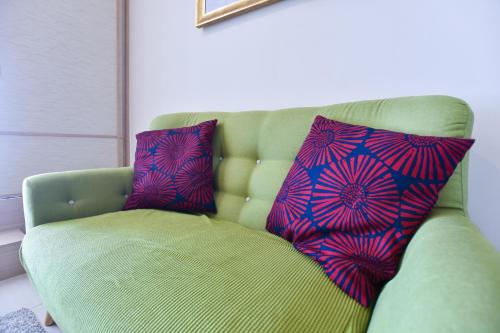 two pillows sitting on a green chair in a room at Kisetsu no ie, KLCC Kuala Lumpur in Kuala Lumpur