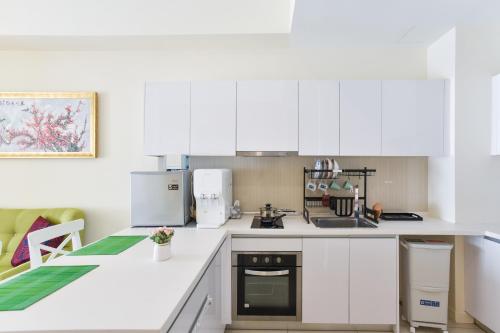 a white kitchen with white cabinets and appliances at Kisetsu no ie, KLCC Kuala Lumpur in Kuala Lumpur