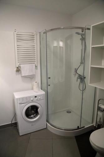 a bathroom with a shower and a washing machine at Motel Dymek in Dębica