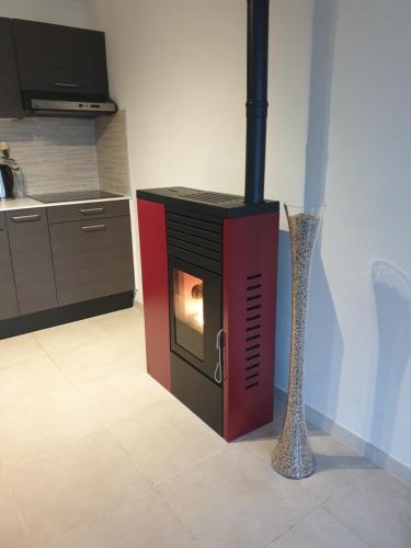 a fireplace in a kitchen with a vase next to it at Les terrasses de Malmédy in Malmedy