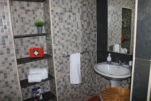 un piccolo bagno con lavandino e specchio di Casa da Avó Rita a São Pedro do Corval