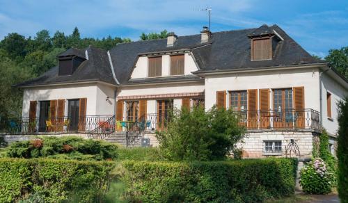 una gran casa blanca con techo negro en Le Curieux de Conques en Saint-Cyprien-sur-Dourdou