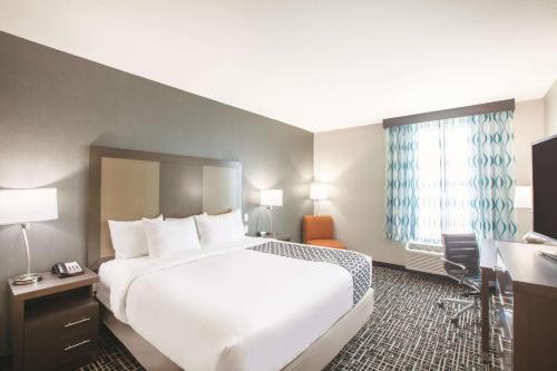 a hotel room with a large bed and a desk at La Quinta by Wyndham San Marcos Outlet Mall in San Marcos