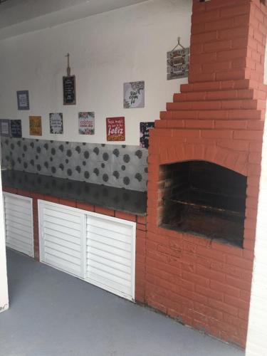 a brick oven with two white garage doors and a brick wall at Meus Guris in Arraial do Cabo