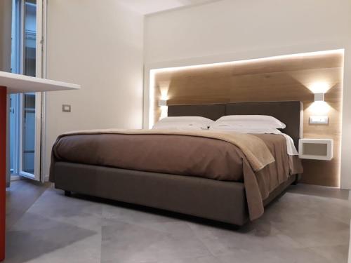 a bedroom with a large bed with a wooden headboard at Casa Due Maggio in Cava deʼ Tirreni