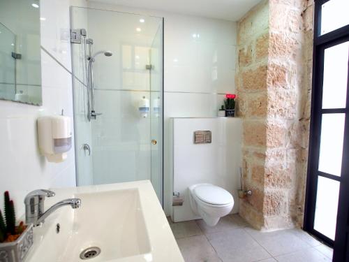a bathroom with a shower and a toilet and a sink at New Imperial Hotel in Jerusalem