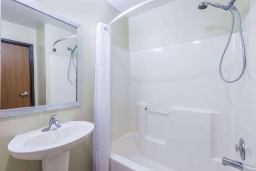 y baño blanco con lavabo y ducha. en Days Inn by Wyndham Pueblo, en Pueblo