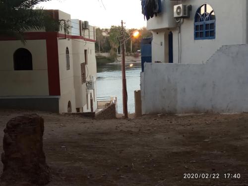 a building next to a body of water at ABAZIDO Nubian Guest House in Aswan