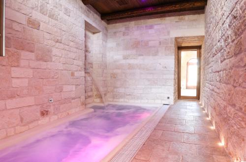 a room with a hot tub in a stone wall at Trulli e Puglia Luxury Suite in Alberobello