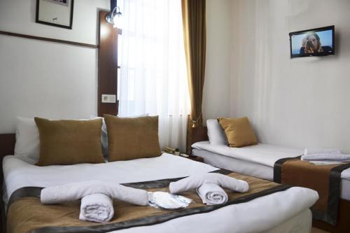 a hotel room with two beds with towels on them at Konak Hotel Kaleiçi in Antalya