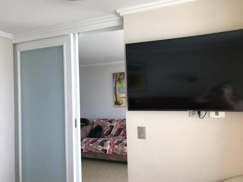 a living room with a flat screen tv on a wall at Una vista increíble al Pacifico in Concón