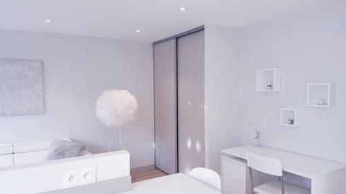 een witte kamer met een bureau en een spiegel bij Le White Cosy à 5 minutes du Lac avec parking privatif gratuit in Annecy