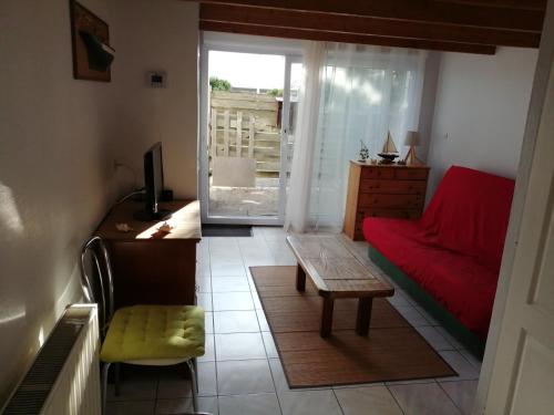 een woonkamer met een rode bank en een tafel bij abri/cotier in Châtelaillon-Plage