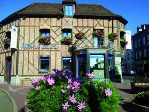 un edificio con flores delante en GITE DE L'AVENUE VERTE, en Forges-les-Eaux