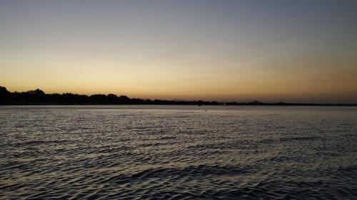a large body of water with the sunset in the background at Norman Carr Cottage in Monkey Bay