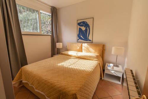 a small bedroom with a bed and a window at Casa Pineta in Diano Marina