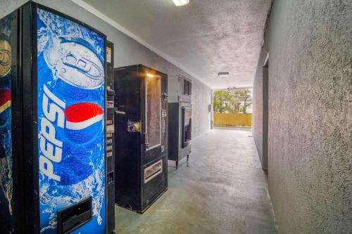 an empty hallway with a vending machine and a soda bottle at Rodeway Inn & Suites Fort Jackson in Columbia