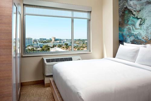 una camera d'albergo con un letto e una grande finestra di Cambria Hotel & Suites Anaheim Resort Area ad Anaheim