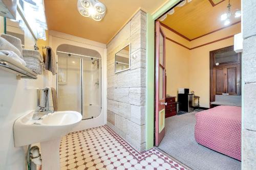 ein Bad mit einem Waschbecken und einer Dusche in der Unterkunft Warwick Settlers Inn in Warwick