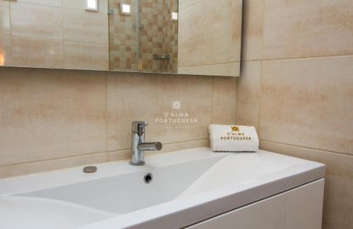 un bagno con lavandino e specchio di Apartment Aveiros Beach- D´Alma Amado a Vale de Pedras