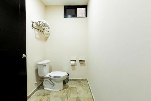 a bathroom with a toilet in a white wall at Hotel Los Frailes, Valladolid, Yucatán in Valladolid