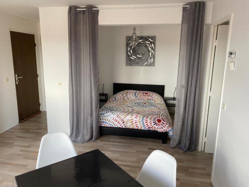 une chambre avec un lit, une table et des chaises dans l'établissement Appartement 300m Plage, à Dunkerque