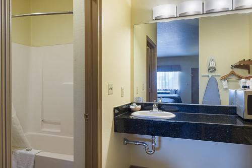 a bathroom with a sink and a mirror at Lone Star Inn and Suites Victoria in Victoria