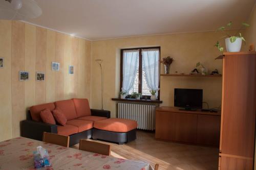 een woonkamer met een bank en een televisie bij casa vacanze al paesello in Orezzo