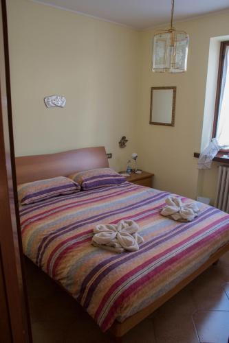 a bedroom with a bed with two towels on it at casa vacanze al paesello in Orezzo