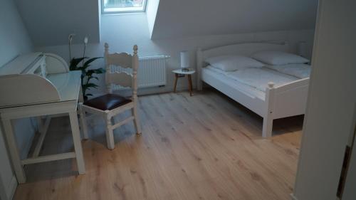 a bedroom with a bed and a desk and a chair at Ferienwohnung Lohf in Handewitt