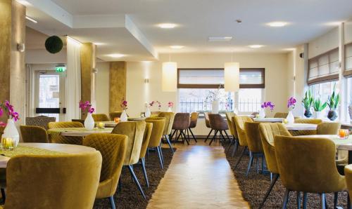 a dining room with tables and chairs and windows at Hotel Schaepkens van St Fijt in Valkenburg