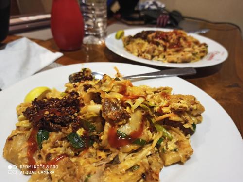 two plates of food on a wooden table at Geethani Tourist Home Polonnaruwa in Polonnaruwa