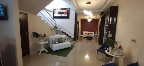 a living room with a white couch and stairs at Hotel Gran Senador in Portoviejo