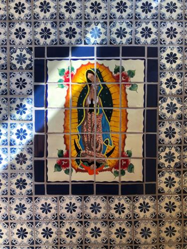 a tile wall with a painting of a woman on it at The Parador in Santa Fe
