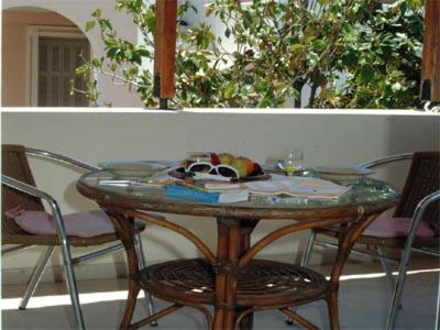 a glass table with chairs and a table with a cake on it at PHILOXENIA PENSION in Ermioni