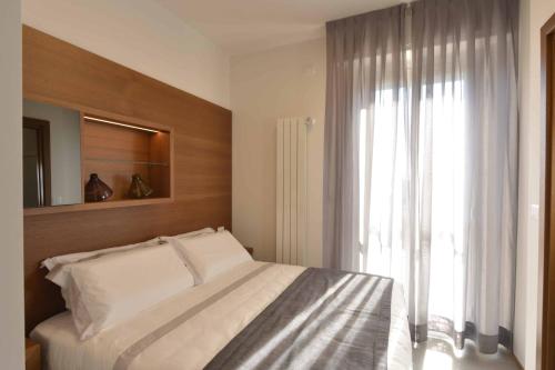 a bedroom with a bed and a large window at Piano Alto Rooms in Pescara