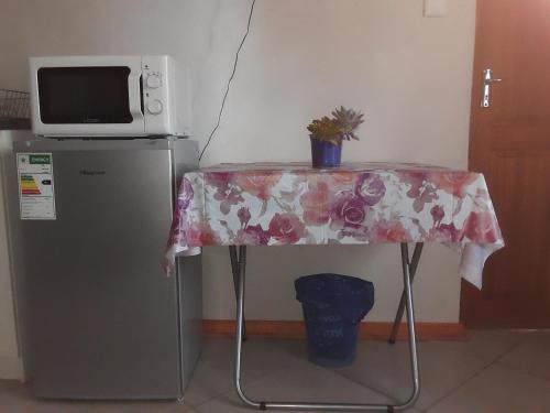 a table with a table cloth on it next to a microwave at Rosy Palm Sunrise in Upington