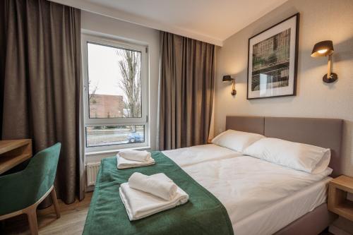 a hotel room with a bed and a window at Marina Apartments in Wrocław