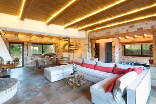 a living room with a white couch and a table at Villa Madera by CorfuEscapes in Kompítsion