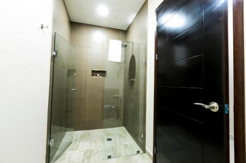 a bathroom with a shower with a glass door at Hotel Los Frailes, Valladolid, Yucatán in Valladolid