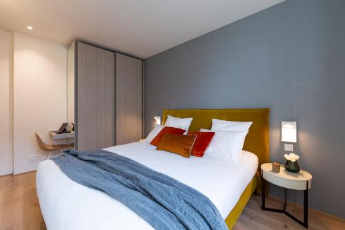 
a bedroom with a bed and a lamp at The Central City - Luxury ApartHotel in Luxembourg

